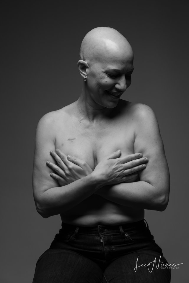 Retrato en blanco y negro de una mujer con los brazos cruzados sobre el pecho.